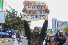 An activist holds a protest poster during a protest against high cost of living and new taxes in downtown Nairobi, Kenya