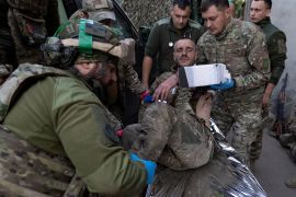 Ukrainian paramedics from 3rd Assault brigade move their wounded comrade on a stretcher arriving from the battlefield to the field hospital near Bakhmut, Donetsk region, Ukraine, Sunday, Sept. 10, 2023.