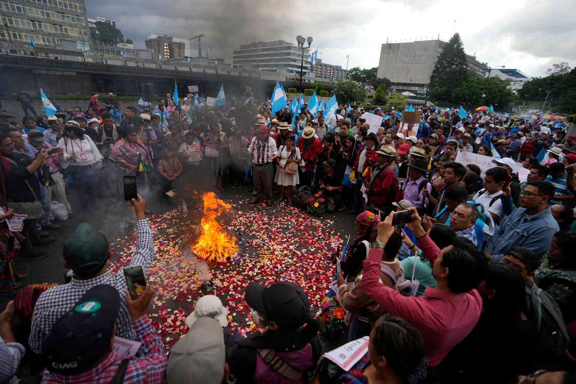 Protesters gather around a fire that burns incense in the streets of Guatemala City.
