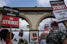 Demonstrators walk with signs during a rally outside the Paramount Pictures Studio in Los Angeles, California [File: Jae C Hong/AP Photo]