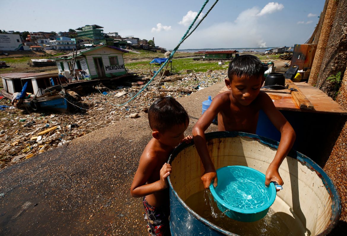 Boys take a bath before going to school near the Negro river, amidst an ongoing drought in Manaus, Brazil