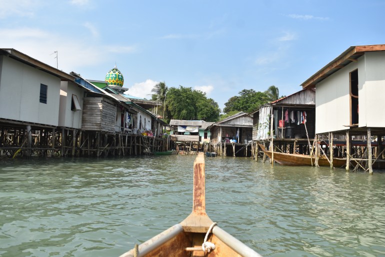 A view of Rempang island's wooden houses from a boat on the water.
