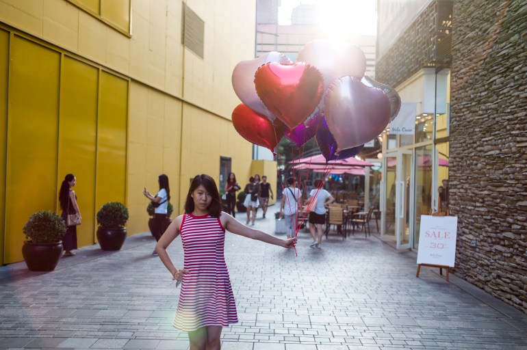 lady poses with balloons during the Chinese valentine's day, on August 9, 2016 in Beijing. Since China's globalization, this traditional festival day known as the most romantic is called today "Chinese Valentine's Day". People celebrate Chinese Valentine's Day by giving flowers or other presents to their beloved.