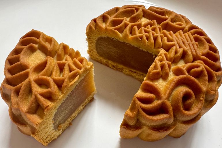 A close-up of a mooncake. It has been cut open to show the inside