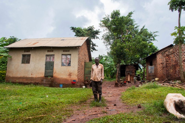 Peter Ganjala poses outside his home in Busamba village, Wakiso, Uganda