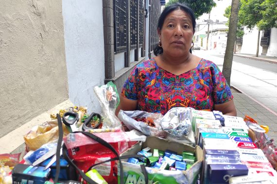 A woman sells good from a cart in Guatemala City