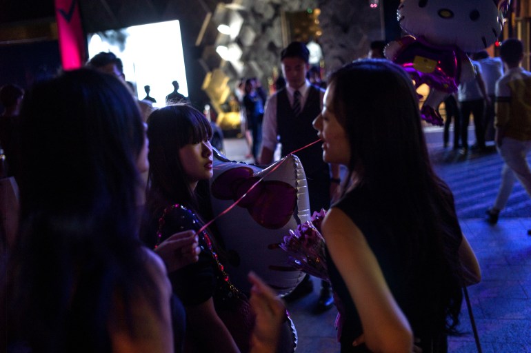 Women hold ballons as a gift at the entrance of a nightclub in Beijing during the Chinese Valentine's Day, on August 20, 2015. Chinese Valentine's Day is on the 7th day of the 7th lunar month in the Chinese calendar and also called Chinese Double Seven Festival. AFP PHOTO / FRED DUFOUR