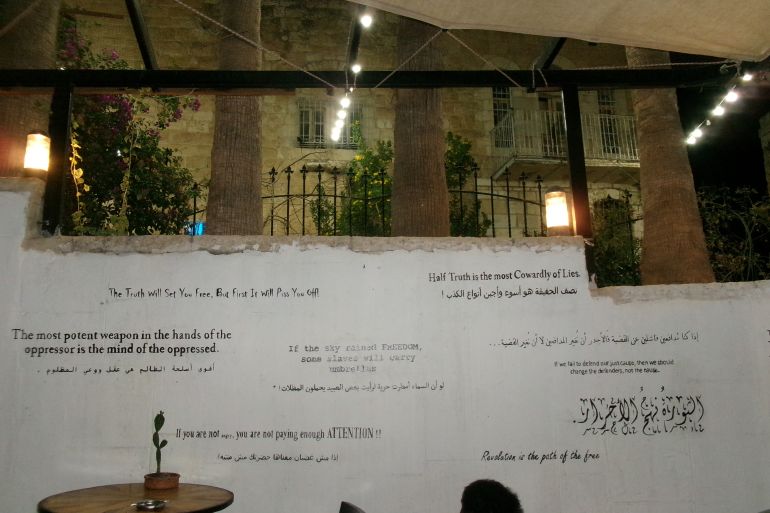 A wall with quotes on Palestine's liberation struggle at the Citadel restaurant in the West Bank on October 10, 2023 [Laila Shadid/Al Jazeera]