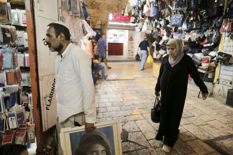An Israeli man walks into a shop as a Palestinian woman stands behind him in Jerusalem's Old City September 10, 2015. While Israel remains predominantly Jewish, Arab numbers within the area of historic Palestine are now close to eclipsing the Jewish population, creating a dilemma for supporters of a "one-state solution" to the region's conflict. REUTERS/Ammar Awad