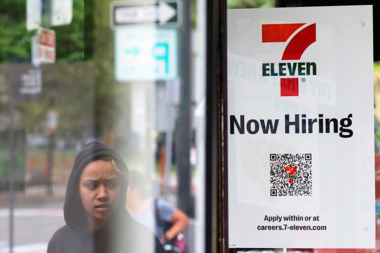 A 7-Eleven convenience store has a sign in the window reading "Now Hiring" in Cambridge, Massachusetts, U.S
