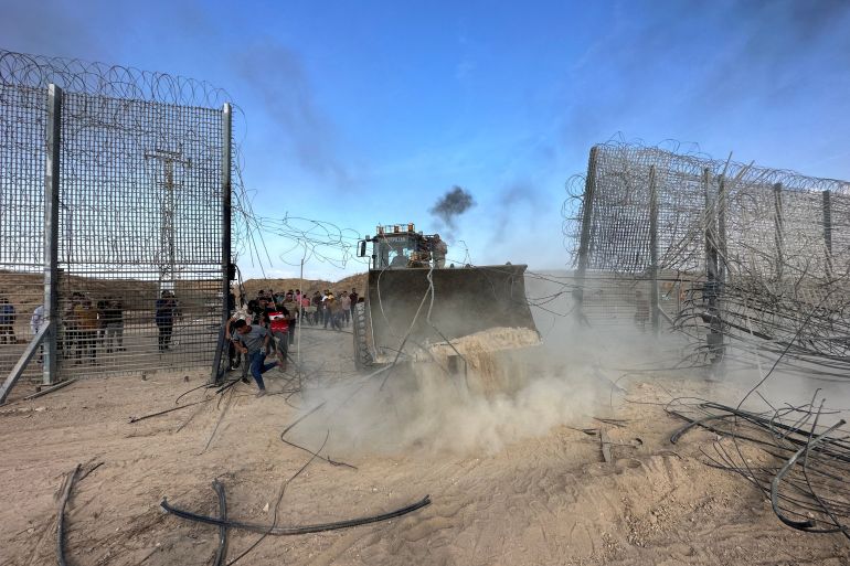 Palestinians break into the Israeli side of Israel-Gaza border fence after gunmen infiltrated areas of southern Israel