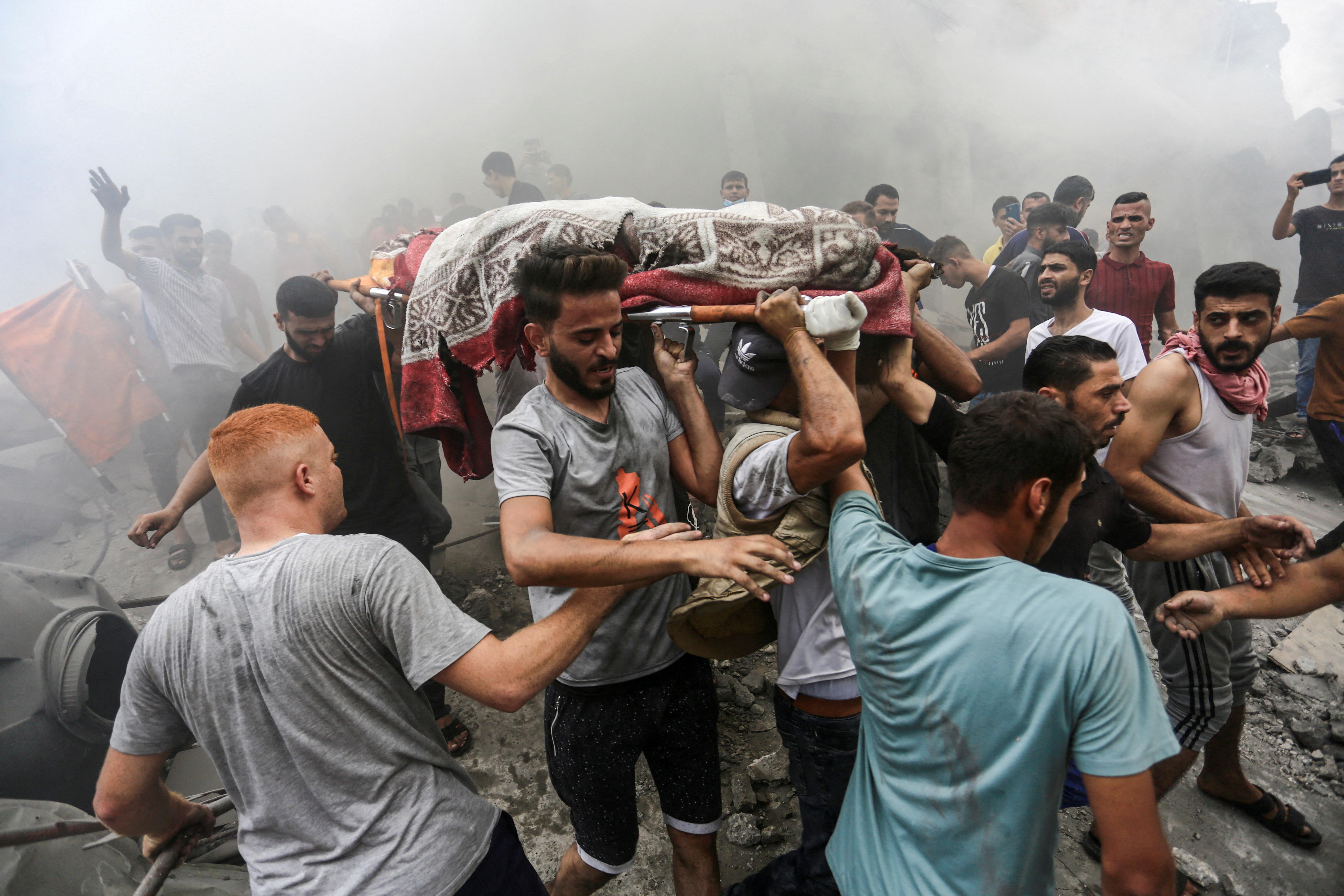 People carry the body of a Palestinian killed in Israeli strikes, in Jabalia refugee camp, in the northern Gaza Strip