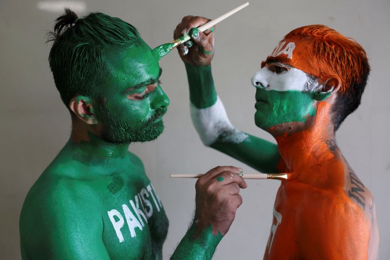 Cricket fans, Arun Haryani (Right) and Anil Advani (Left) paint their bodies in the Indian and Pakistani national flag colours