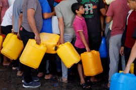 Palestinians gather to collect water, amid shortages of drinking water