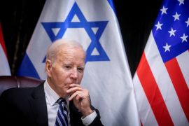Joe Biden with Israeli and American flags behind him