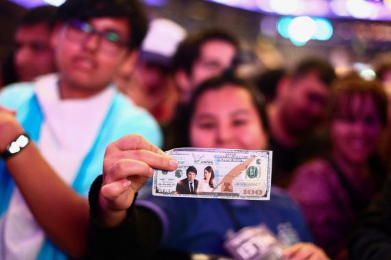 A person holds a mock bill with the face of Vice-President candidate Victoria Villarruel and presidential candidate Javier Milei