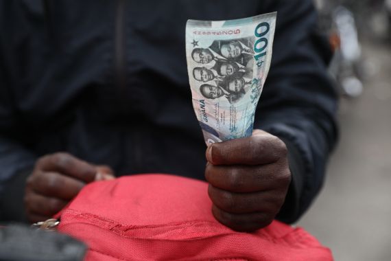 A man holds a 100 cedis, the Ghana currency, note in Accra