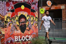 A man walks in front of Redfern train station in Sydney on October 14, 2023, as polls open in Australia's historic Indigenous rights referendum. (Photo by Saeed KHAN / AFP)