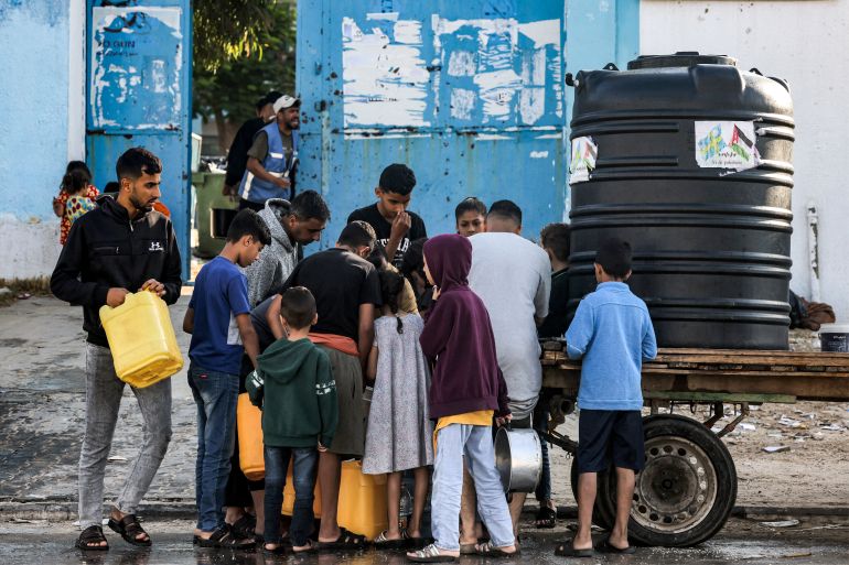 Men and children arrive with jerry cans to fill up water from a portable cistern mounted on a cart in Rafah in the southern of Gaza Strip on October 19, 2023