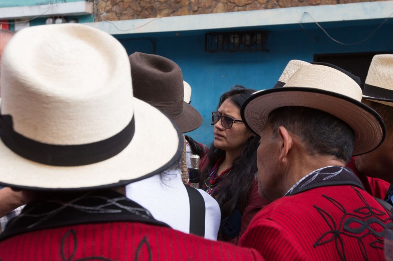 SitPo’p Herrera stands among men in straw hats, wearing sunglasses.
