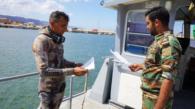 El Hassi and the team captain go over diving locations in search for more bodies