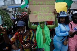 People hold banners as they demonstrate on the street to protest against police brutality in Lagos, Nigeria, October 19, 2020 [Sunday Alamba/AP Photo]