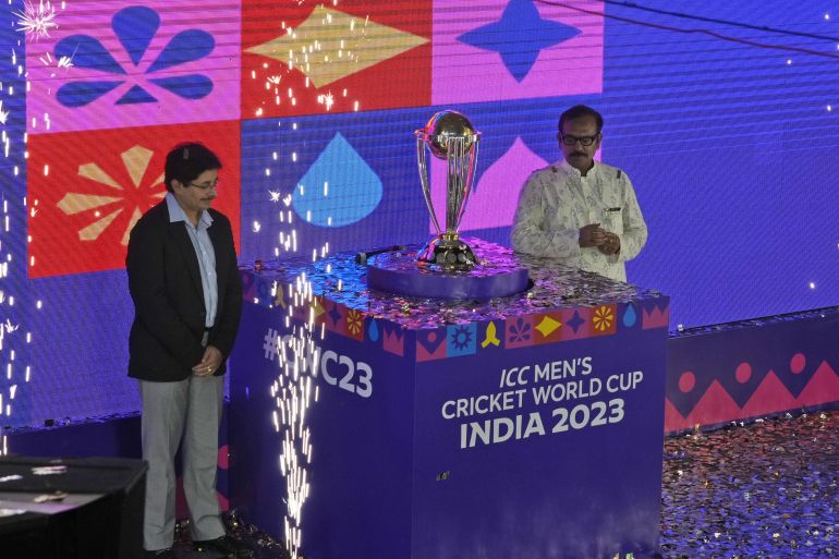 President of Cricket Association of Bengal (CAB) Snehasish Ganguly, left, and Arup Biswas, Minister of sports in Indian state of West Bengal pose with the ICC Cricket World Cup trophy
