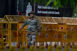 An Indian paramilitary soldier stands guard next to a police barricade outside the Canadian High Commission in New Delhi, India [File: Altaf Qadri/AP]