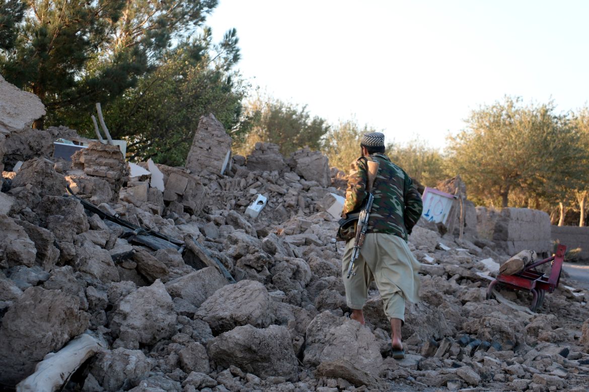 An Afghan man walks by a destroyed home after an earthquake in Zenda Jan district in Herat province, of western Afghanistan
