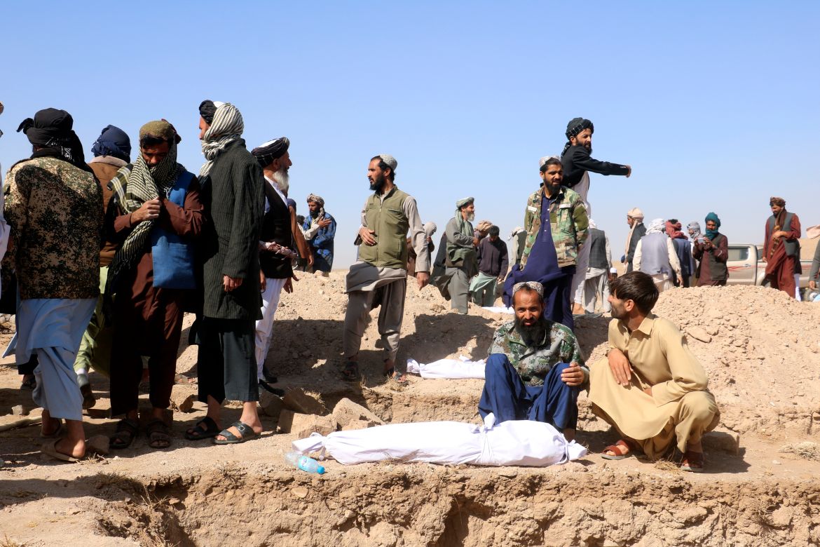 Afghan men bury the victims after an earthquake in Zenda Jan district in Herat province, of western Afghanistan