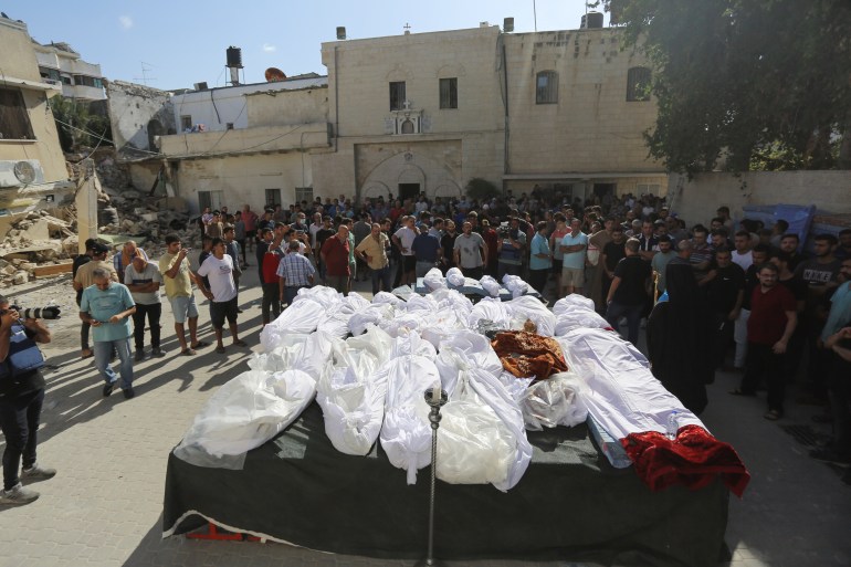 Relatives attend the funeral of Palestinians who were killed in Israeli airstrikes that hit a church, in Gaza City