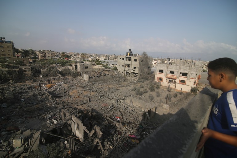 A Palestinian kid looks at he buildings destroyed in the Israeli bombardment of the Gaza Strip in Rafah on Sunday