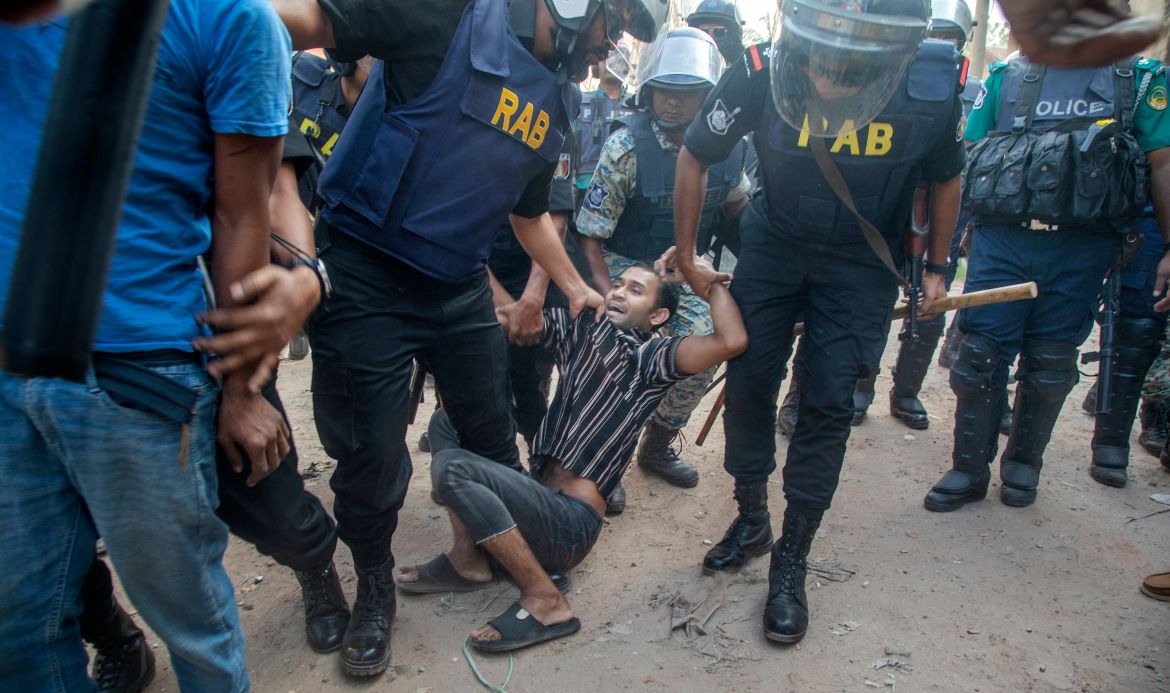Bangladesh Rapid Action Battalion (RAB) members detain a garment worker during clashes in Gazipur city, on the outskirts of Dhaka, Bangladesh.
