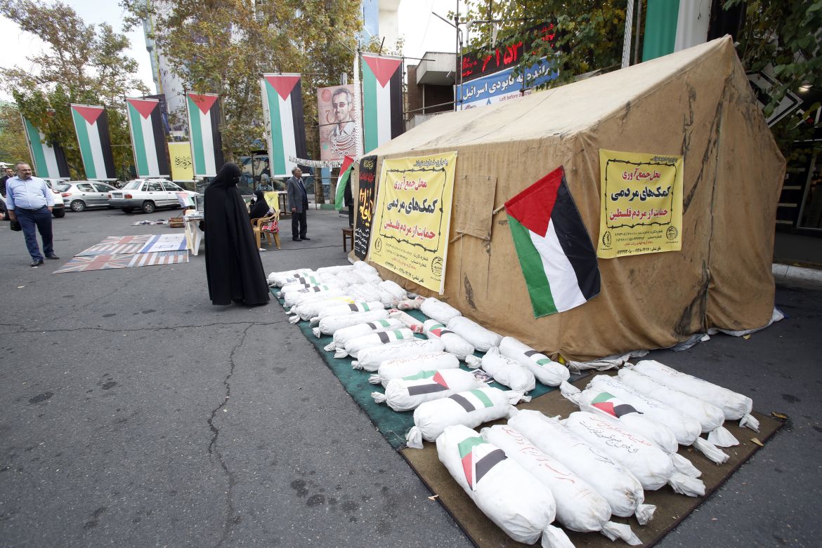 People stand near mock objects depicting deceased children during a campaign to collect money and aid material for Palestinians in Gaza at Palestine square, in Tehran, Iran.