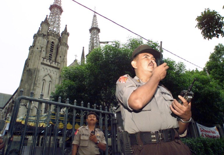 INDONESIAN POLICE PROVIDE SECURITY OUTSIDE JAKARTA'S MAIN CATHEDRAL THE DAY AFTER BOMB BLASTS ROCKED THE CITY. An Indonesian police officer provided security outside the capital's main Cathedral during morning mass December 25, 2000. Indonesia's Christians on Monday flocked to churches throughout the country hours after a spate of deadly Christmas bomb atttacks killed at least ten people in this predominantly Muslim country.