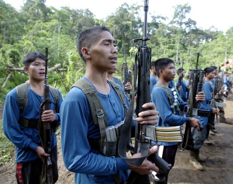 Members of the New Peoples Army (NPA), armed group of the Communist Party of the Philippines, sing "Internationale" during graduation after their military training in their jungle hideout in Lianga on southern Mindanao island March 13, 2004. Members of the world's oldest communist insurgency see little hope of peaceful change in the Philippines and have vowed to step up their rebellion with the help of weapons obtained from the military. Photo taken March 13.