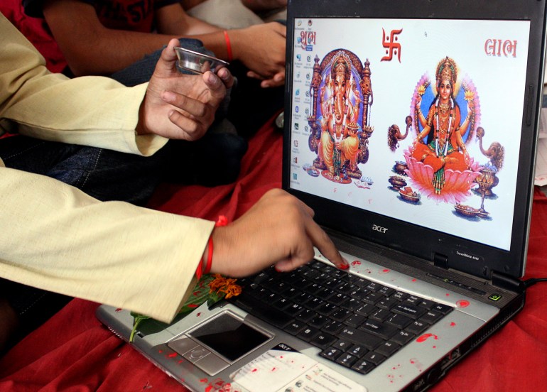 A businessman offers prayers to Hindu gods in front of a laptop as part of a ritual to worship the Hindu deity of wealth "Goddess Lakshmi" on Diwali, the Indian festival of lights, in the western Indian city of Ahmedabad October 28, 2008. The ritual known also as "Muhurat trading" is considered auspicious by traders and marks the beginning of the new trading year for the Gujarati community in India, who form the bulk of share brokers and businessmen in India. 