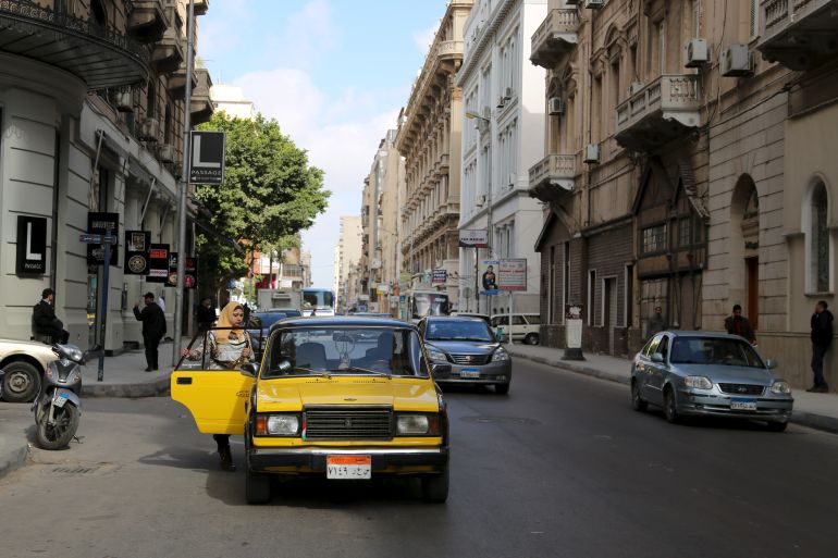 A woman gets into a yellow and black cab in front of L-Passage food hall on Fouad street in Alexandria, Egypt, February 23, 2016.