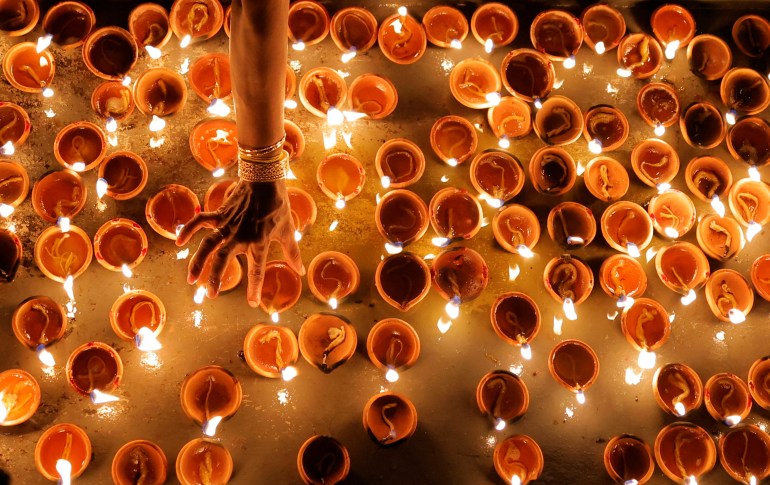 A Tamil devotee lights an oil lamp at a religious ceremony during the Diwali or Deepavali festival at Ponnambalavaneshwaram Hindu temple in Colombo, Sri Lanka ,