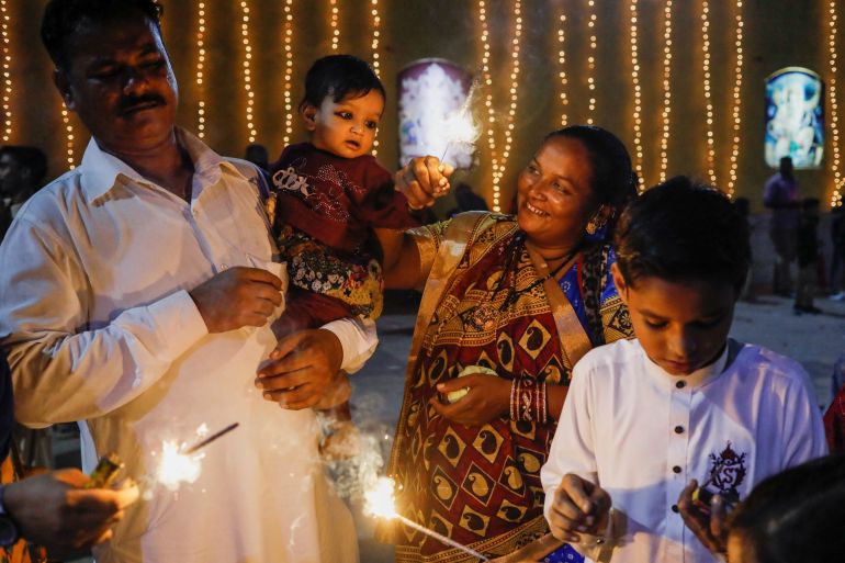 Sawantri, 40, helps her son to wave a burning sparkler during Diwali, the Hindu festival of lights, in Karachi, Pakistan.