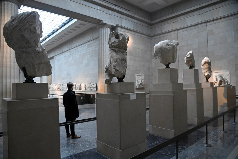 An employee poses as he views examples of the Parthenon sculptures, sometimes referred to in the UK as the Elgin Marbles, on display at the British Museum in London, Britain, January 25, 2023. REUTERS/Toby Melville