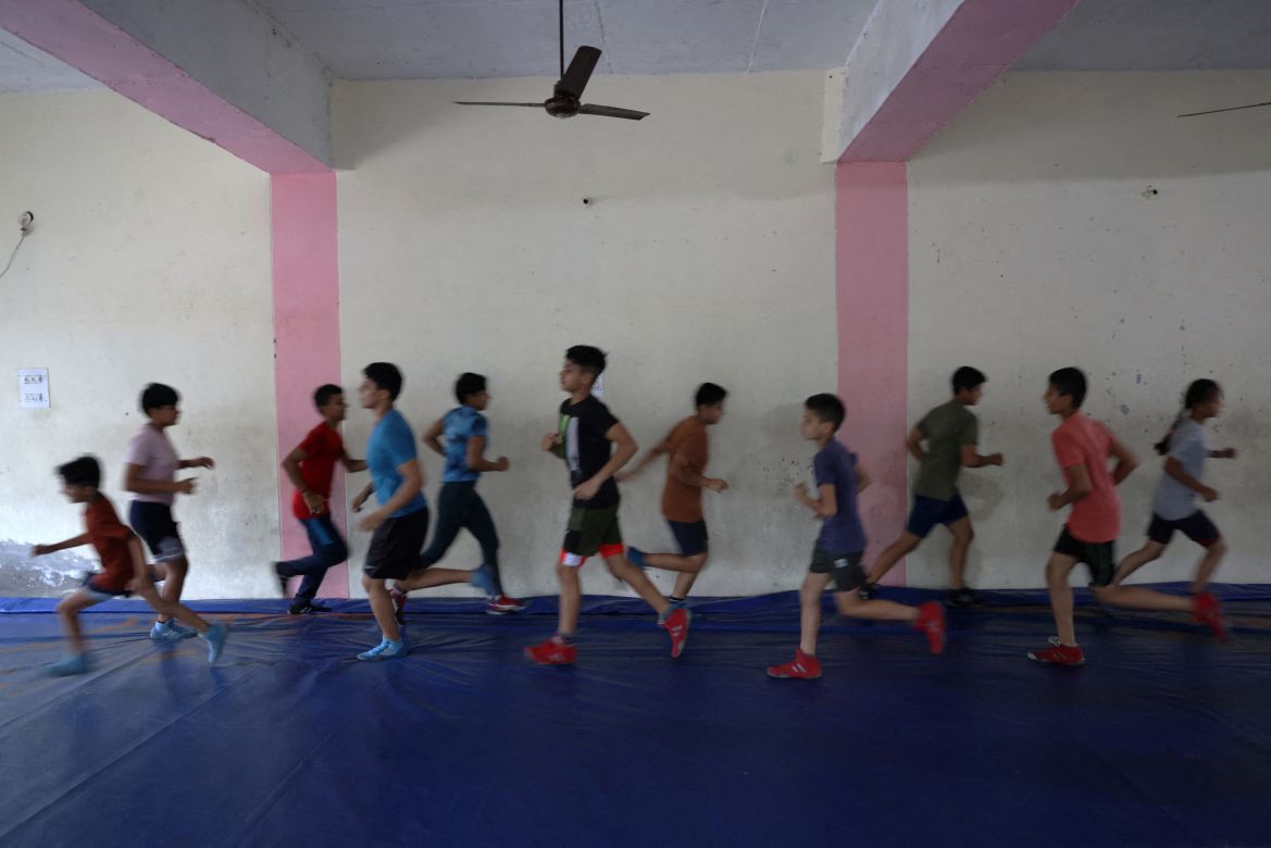 Students run as a warm-up exercise before their wrestling bouts, at the training room in the Altius wrestling school in Sisai, Haryana, India.