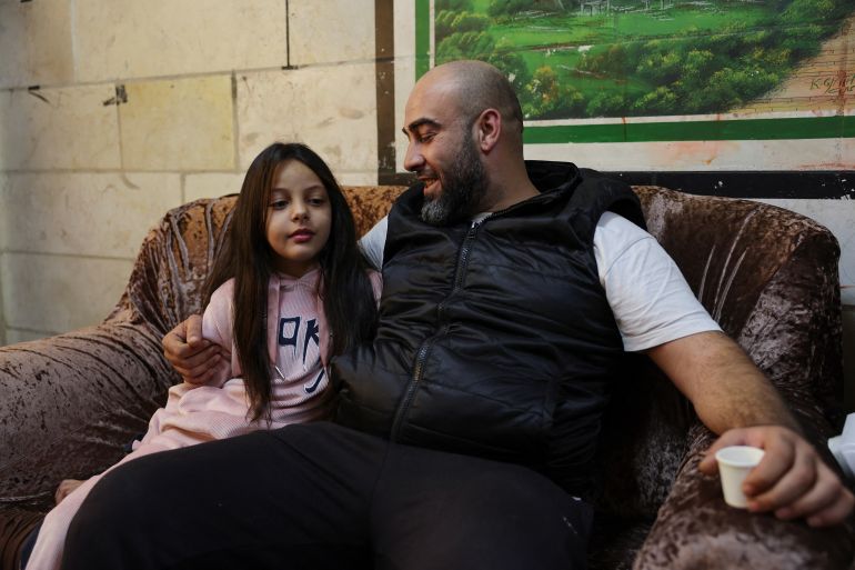 Palestinian Eyad Banat who was detained by Israeli troops while doing a live broadcast, talks to his daughter Sandi in his house in Hebron in the Israeli-occupied West Bank, November 13, 2023. REUTERS/Mussa Qawasma