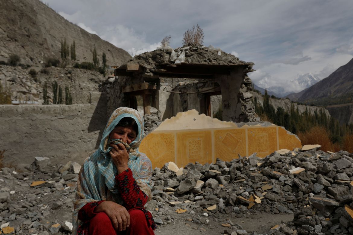 Dilshad Bano, 51, sits on the floor near her house which was damaged after a Glacial Lake Outburst Flooding (GLOF) incident, in Hassanabad village, Hunza valley, in the Karakoram mountain range in the Gilgit-Baltistan region of Pakistan.