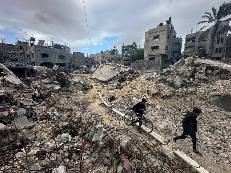 Palestinians walk among the rubble, as they inspect houses destroyed in Israeli strikes during the conflict, amid the temporary truce between Hamas and Israel, at Khan Younis refugee camp in the southern Gaza Strip November 27, 2023. REUTERS/Mohammed Salem