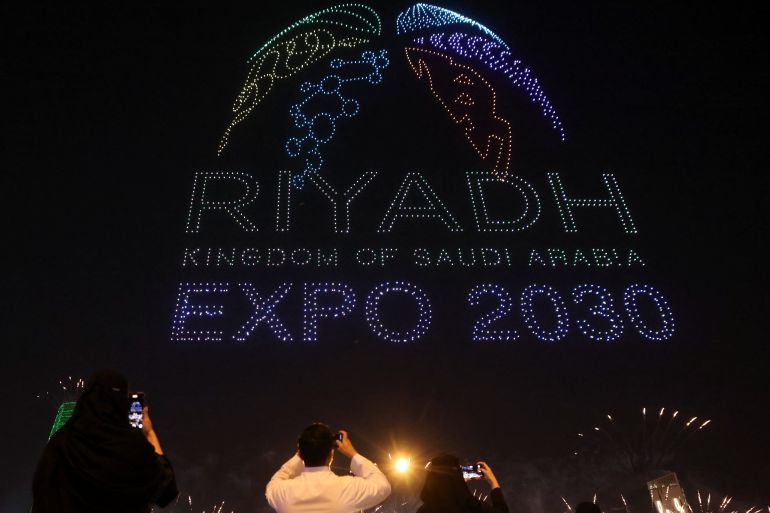 People watch a fireworks show celebrating Saudi Arabia's successful bid to host the 2030 world fair