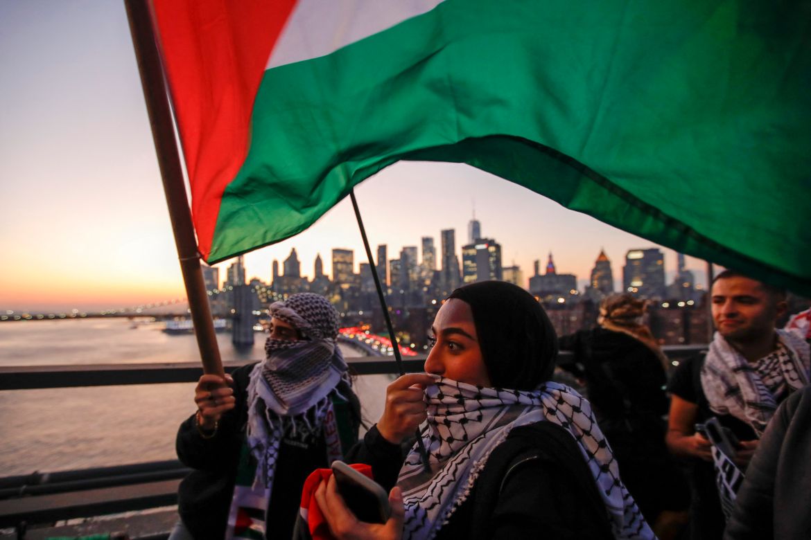 Demonstrators hold Palestinian flags as they march through Brooklyn Bridge during a rally in support of Palestinians in New York City.