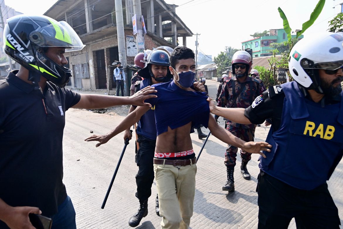 Rapid Action Battalion (RAB) personnel detain a garment worker (C) protesting in Gazipur on November 9, 2023, after the Minimum Wage Board authority declared the minimum wage of 12,500 taka ($113) for garment workers.