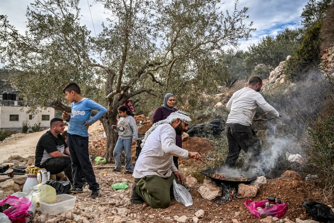 A Palestinian man cooks for his family during the olive harvest at a grove outside Ramallah in the occupied West Bank.