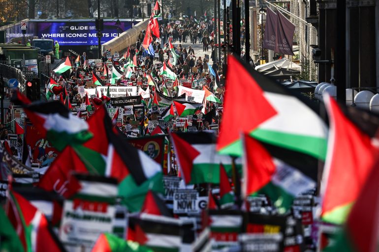 Protesters holding placards and Palestinian flags take part in a 'National March For Palestine' in central London.